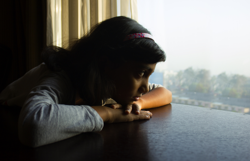 An Indian girl is sad because she is alone and waits for the good days.